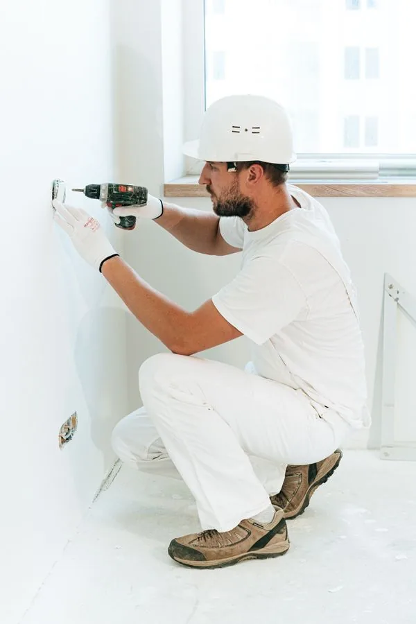 A worker fitting a wall socket inside a home