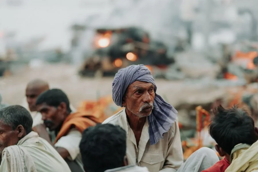 An older worker in a headscarf among a waiting crowd
